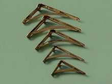 Set of five metallic brackets on a green background